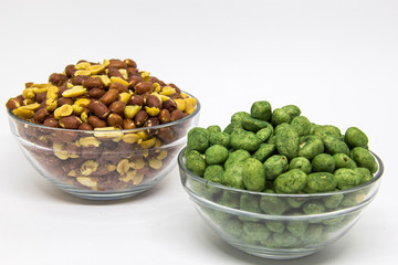 Roasted peanuts in glass bowl on white background