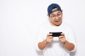 Funny Young Asian Guy Playing Games on Tablet Smart Phone