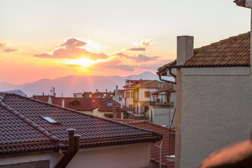 cityscape landmark shingles roofs and evening sunset rays light and glare 