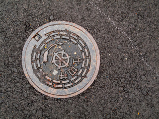 Manhole cover in road, Japan.