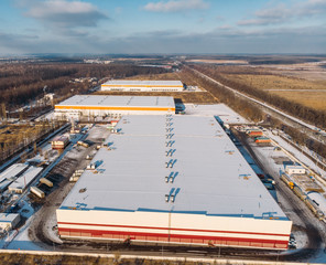 Aerial view of warehouse storages or industrial factory or logistics center from above. Top view of industrial buildings and trucks