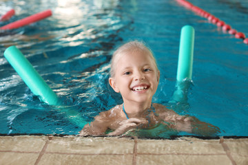 Little girl with swimming noodle in indoor pool © New Africa