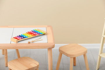 Stylish child's room interior with rainbow glockenspiel on wooden table