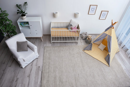 Cozy baby room interior with play tent and toys, above view