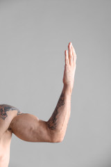 Plakat Tattooed man on grey background, closeup of arm
