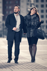 Happy young fashion couple walking on city street