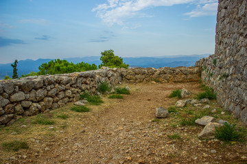 soft focus stone walls of ancient medieval castle ruins on top of rock in highland mountain landscape environment 