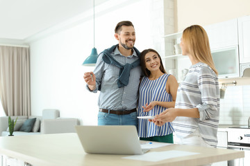 Female real estate agent working with couple, indoors