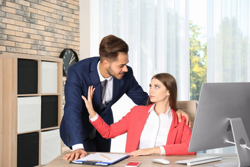 Boss molesting his female secretary in office. Sexual harassment at work