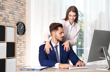 Woman molesting her male colleague in office. Sexual harassment at work