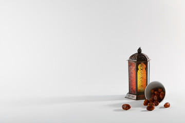 Fototapeta premium Muslim lamp and dates on white background. Space for text