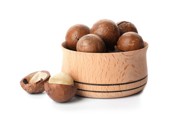 Bowl with organic Macadamia nuts on white background