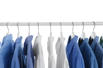 Men clothes hanging on wardrobe rack against white background, closeup