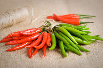 green and red chilli peppers on sackcloth