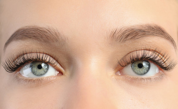 Young woman with beautiful long eyelashes, closeup. Extension procedure
