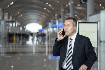 Business man at the airport talking with phone