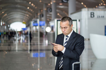 Business man at the airport checking passport and ticket