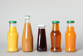 Bottles with different drinks on color background