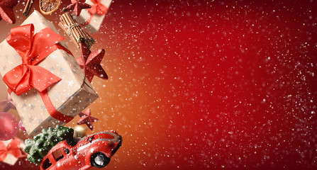 Falling Christmas gift with ornaments on red, snowy background