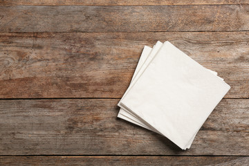 Clean napkins on wooden background, top view with space for text - obrazy, fototapety, plakaty