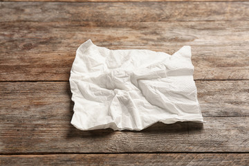 Crumpled napkin on wooden background. Personal hygiene