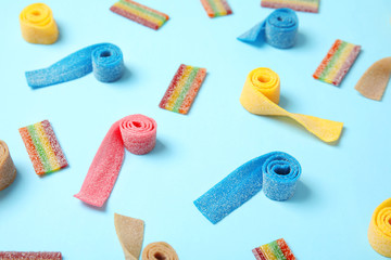 Composition with different yummy candies on color background