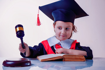 Justice and law concept.  Little cute child girl judge in a courtroom striking the gavel. Humorous...