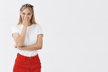 Portrait of happy and joyful attractive young caucasian girl with fair hair covering half of face...