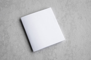 Blank portrait mock-up paper. brochure magazine isolated on gray, changeable background / white paper isolated on gray cement backdrop.