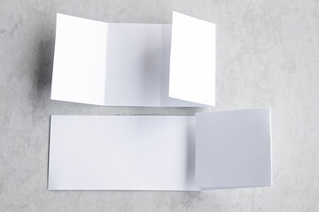 Blank portrait mock-up paper. brochure magazine isolated on gray, changeable background / white paper isolated on gray cement backdrop.