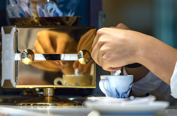 Man hands pouring sugar on his espresso coffee cup, indoors.