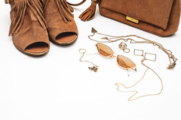 Fashionable lady. Suede sandals, bag, glasses and jewelry on a white background. Brown color