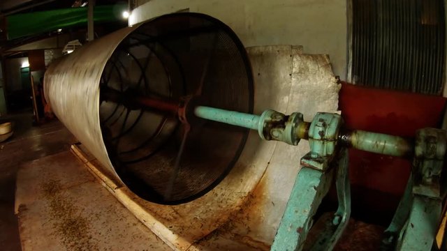 Sifting tea through rotating mesh tube old indian factory