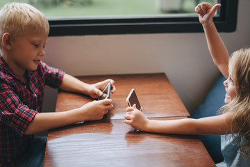 Little boy playing a mobile game against his sister