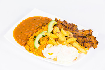 Ecuadorian national dish with rice, beans, pork, french fries, eggs and avocado 