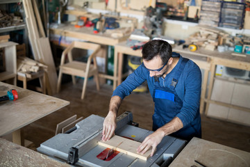 High angle portrait of mature carpenter working with wood in joinery, copy space