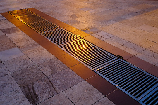 Metal grille drainage on marble floor tiles