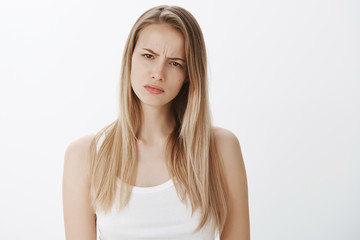 Girl suspects something wrong being doubtful in friend telling whole truth, squinting suspicious at...