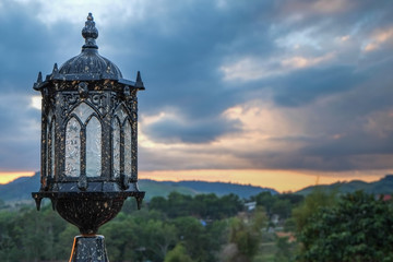 The old-fashioned lamp at sunset in nature in the hill