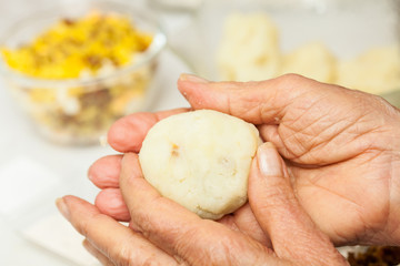 Preparation steps of traditional Colombian dish called stuffed potatoes : Stuffing the mashed potatoes dough for the stuffed potatoes
