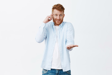 Man mocking friend who made stupid mistake. Portrait of confused and displeased handsome redhead...