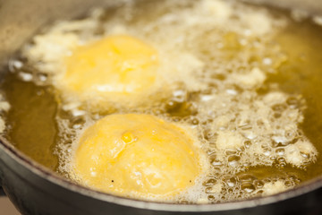 Preparation steps of traditional Colombian dish called stuffed potatoes : Deep frying stuffed pototoes