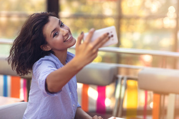 Young woman taking a selfie in coffee shop