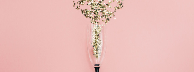 Champagne glass poured out golden stars confetti - obrazy, fototapety, plakaty
