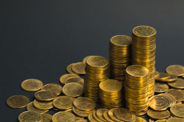 Savings, increasing columns of coins, piles of coins arranged as a graph in dark room, business banking concept.