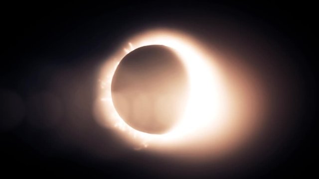 Abstract solar eclipse caused by a Lunar event with ring of fire on black background. Animated abstract view of a total solar eclipse.