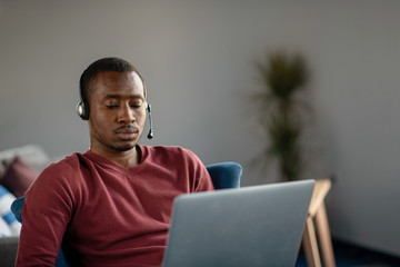 Emotional dark skinned male freelancer celebrating completed project successfully.