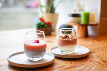 Close up Dietary vegan healthy breakfast. Yogurt and granola with mint in glass On wooden table.