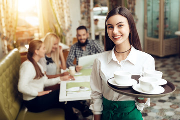 Portrait smiling young waitress standing in cafe