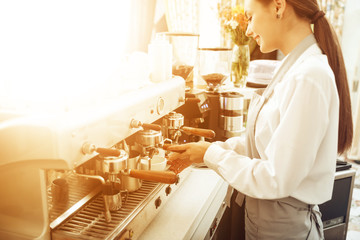 Beautiful young girl barista preparing coffee